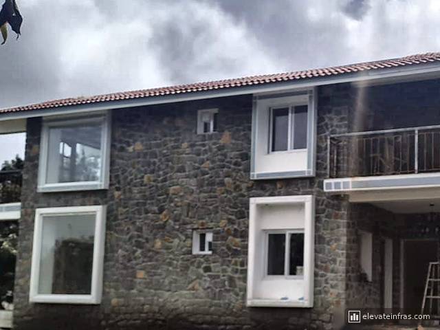 Stone walls, tiled roof and large windows of the second building