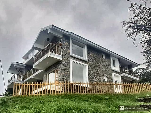 The second building on the hillside behind its wooden fence
